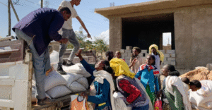 An image of people in Tigray receiving food from a truck. They are mostly older women.