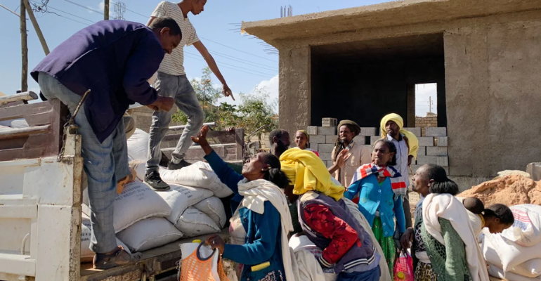 An image of people in Tigray receiving food from a truck. They are mostly older women.